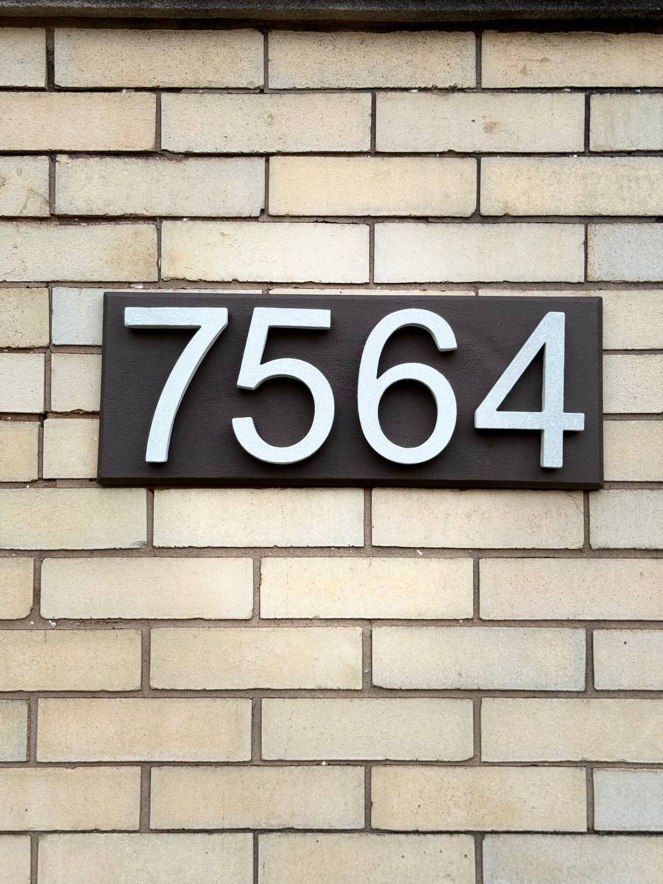 Installed Heritage Brown GFRC address plaque on light brick