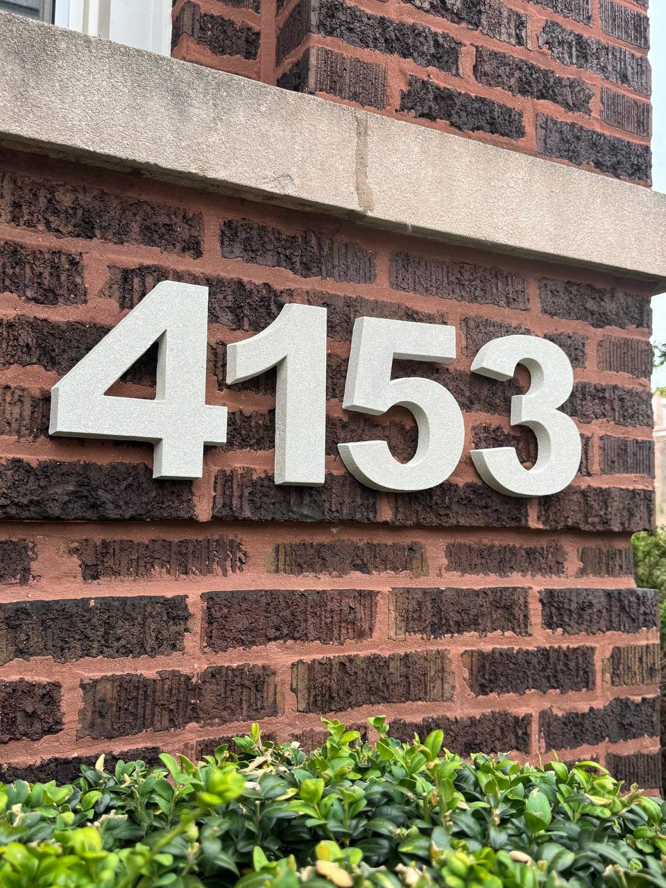 Installed GFRC house numbers with brick and landscape context