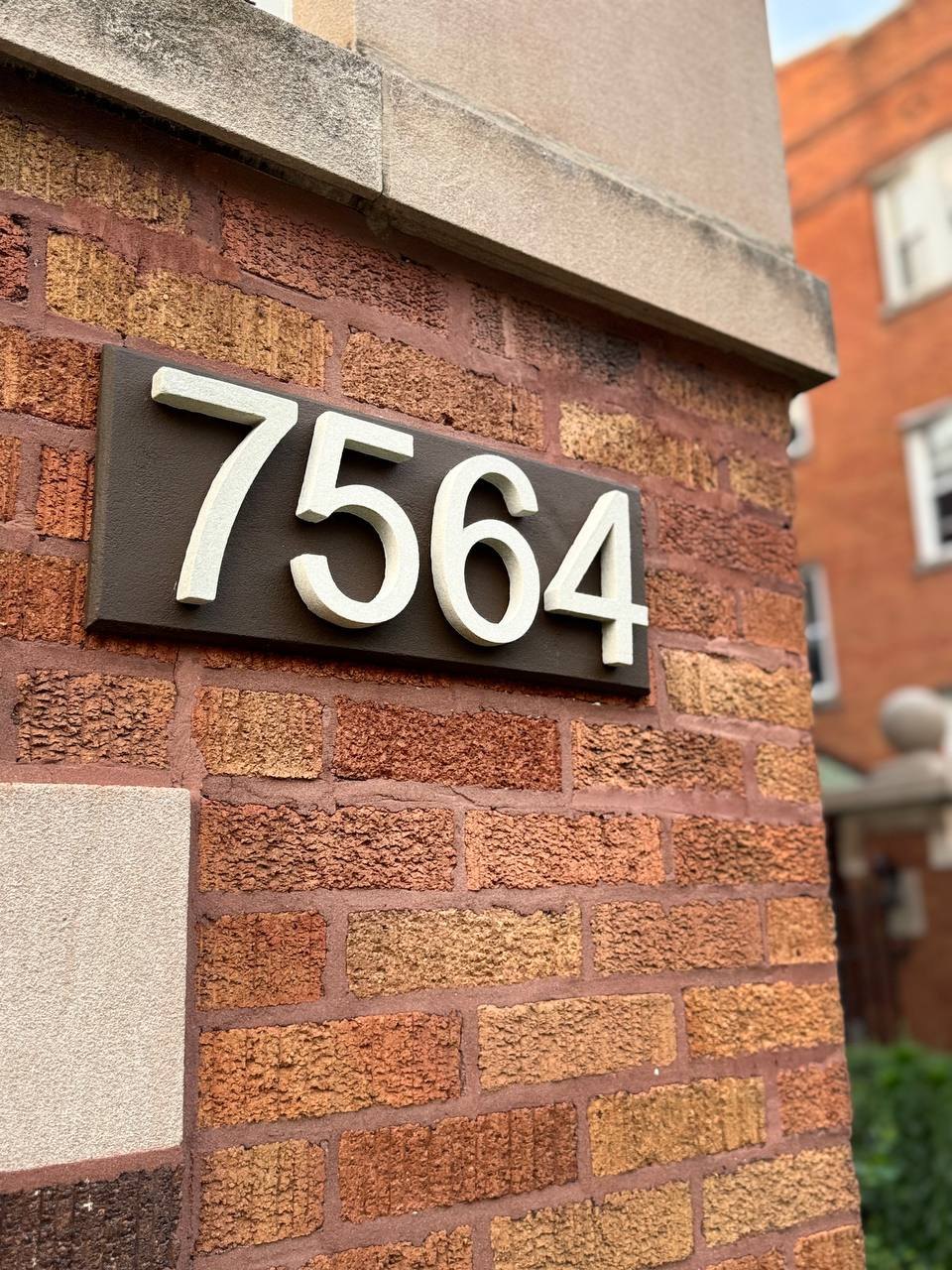 Heritage Brown ArchStone GFRC address plaque with raised dimensional numbers on brick
