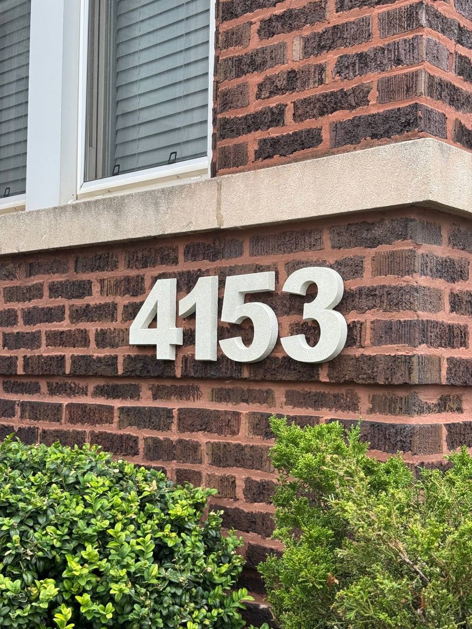 Large raised 4153 stone numbers on red brick