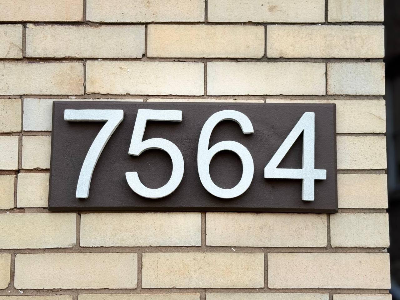 7564 raised stone address plaque installed on light brick